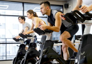 foto de varias pessoas lado a lado fazendo spinning em academia