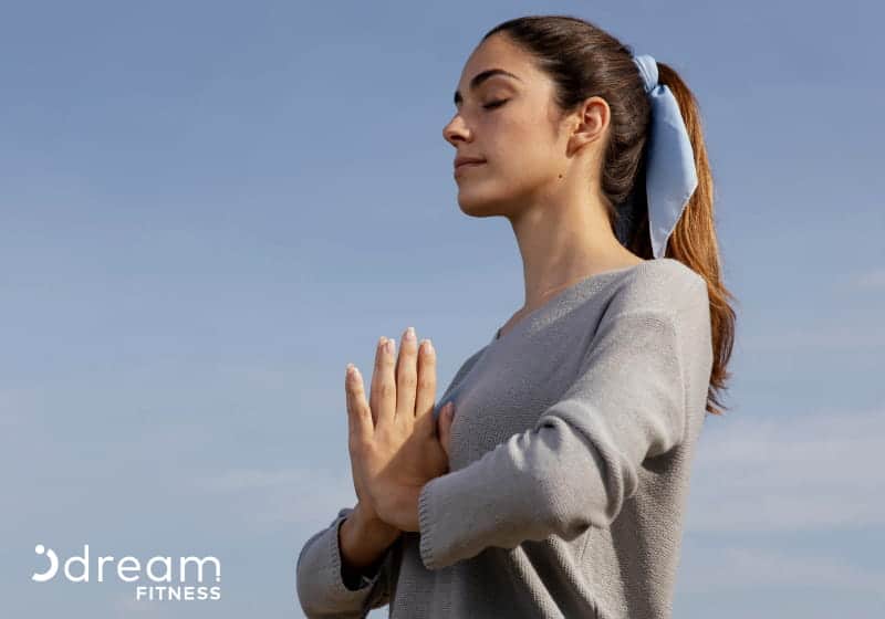 mulher fazendo tecnica de respiração e ceu azul