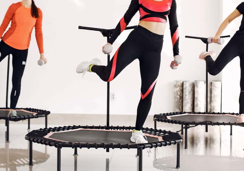 aulas de jump ajudam a emagrecer 3 mulheres treinando no trampolim
