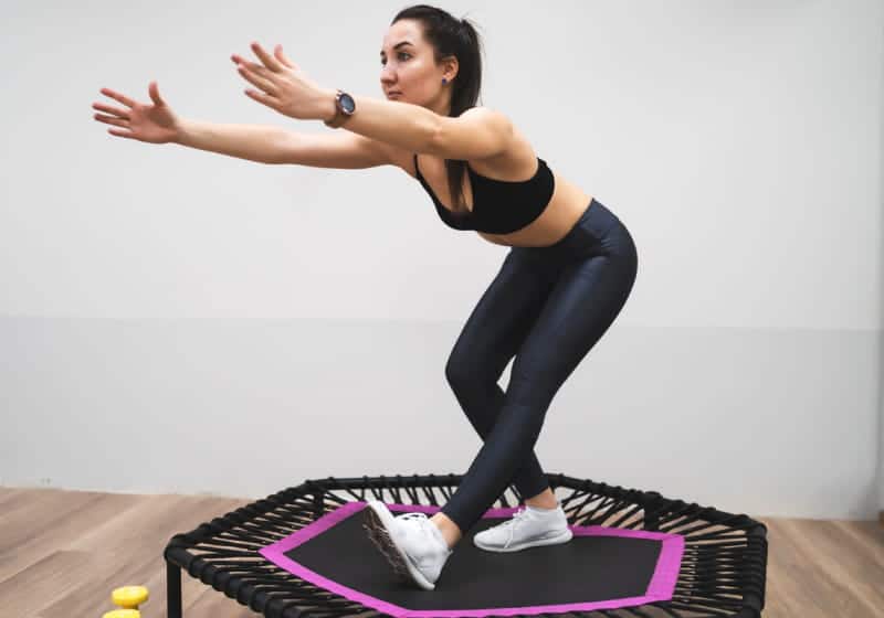 beneficios do jump para a saude mulher fitness se equilibrando em cima trampolim