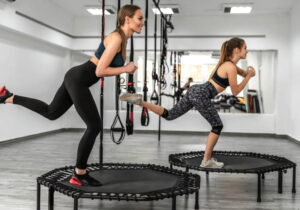 duas garotas fazendo exercício no trampolins da academia