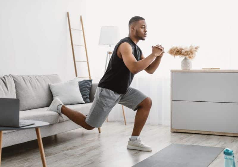Homem fazendo agachamento búlgaro em casa