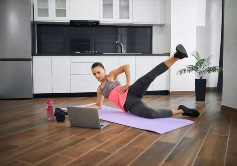Mulher treinando elevação de perna em casa