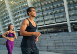 homem e uma mulher correndo enfrente a um prédio
