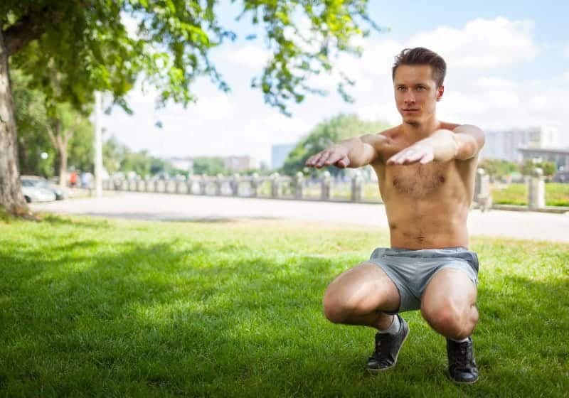 homem fazendo agachamento ao ar livre