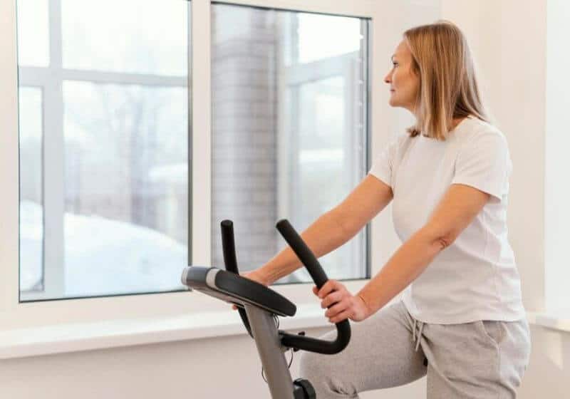 mulher olhando para o lado em cima de uma Bicicleta ergométrica 