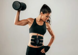 mulher musculosa fazendo bispes com tonificador muscular no abdome