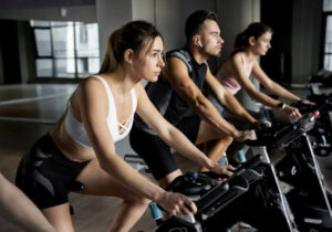Pessoas fazendo aeróbico na bicicleta ergométrica