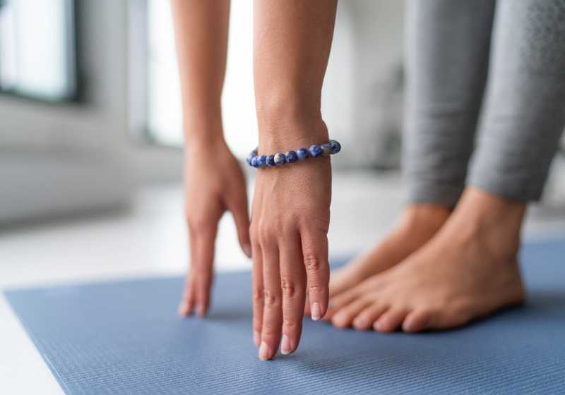 Imagem das mãos e pés de uma mulher se alongando em cima de um tapete