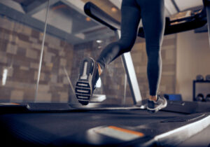 Imagem de uma mulher realizando um treino na esteira