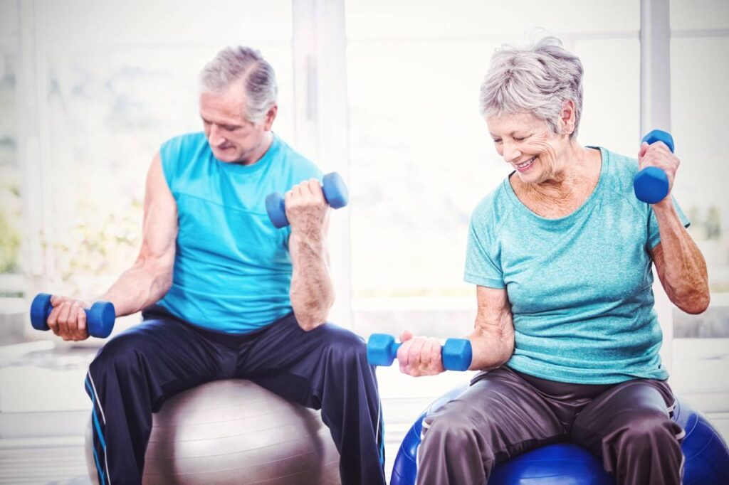 Casal de idosos realizando exercícios de fortalecimento muscular