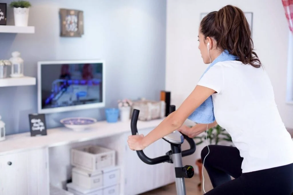 Woman on exercise bike exercising and watching TV