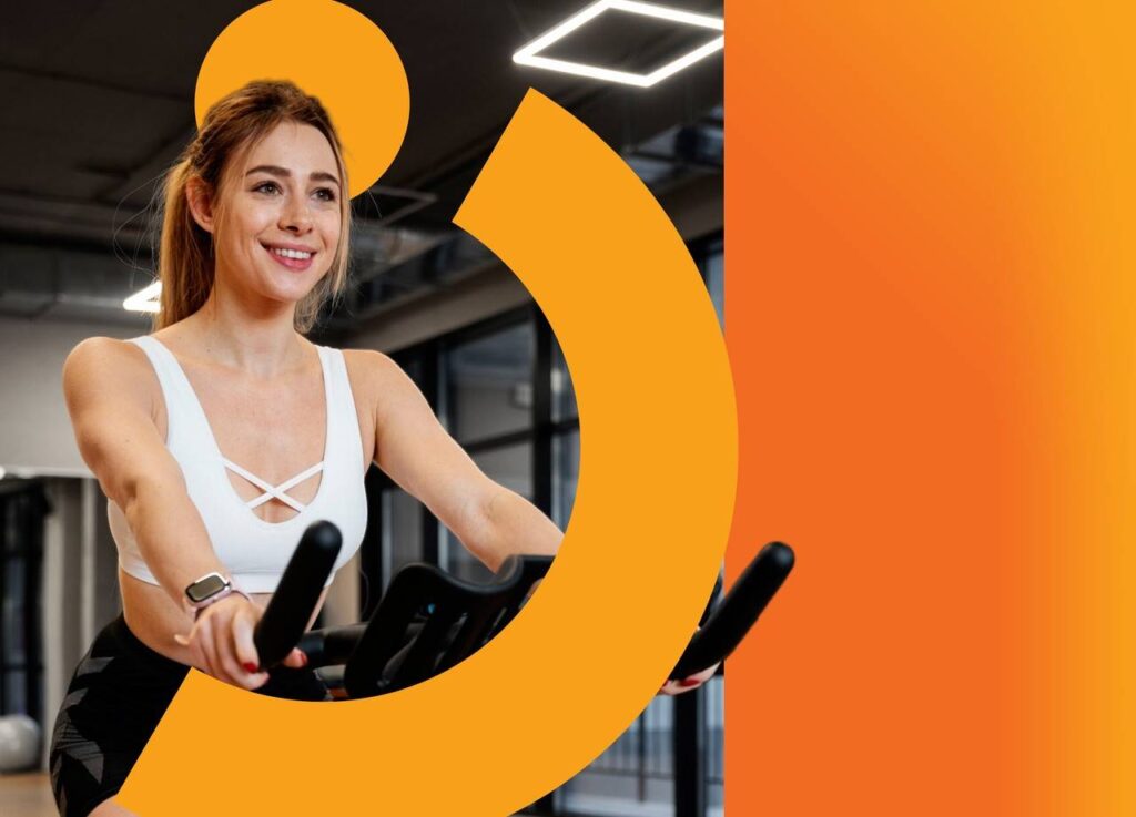 Mulher pedalando em bicicleta dentro de academia